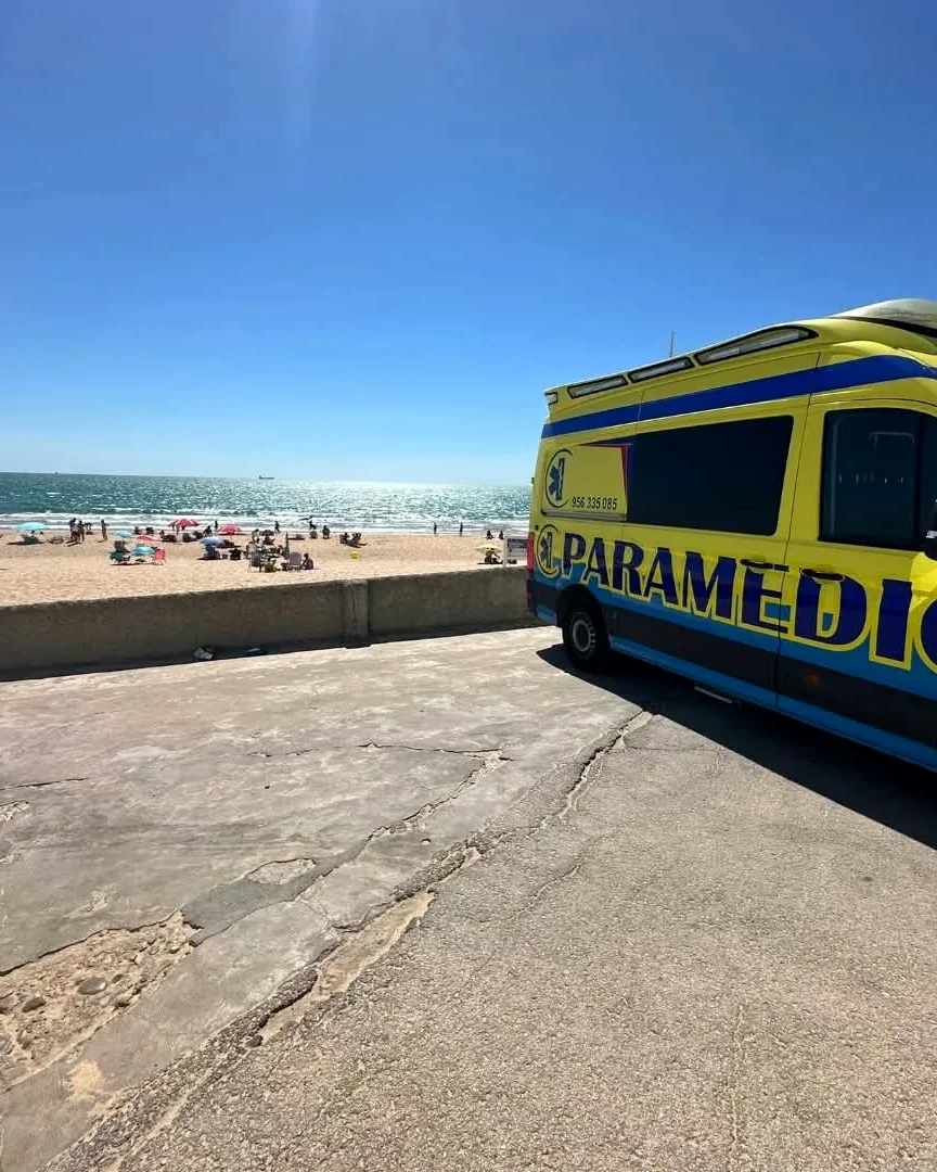 Ambulancia de Paramedic junto a una playa llena de bañistas en la provincia de Cádiz